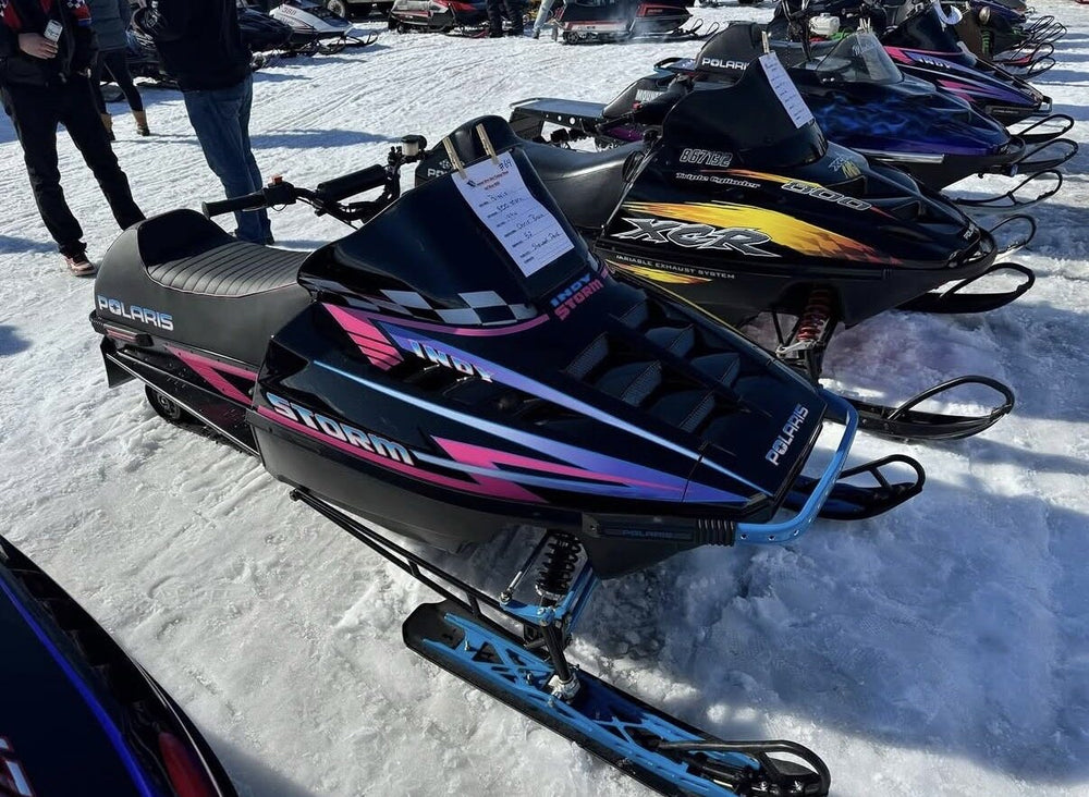 Restored vintage Polaris snowmobiles at an outdoor show