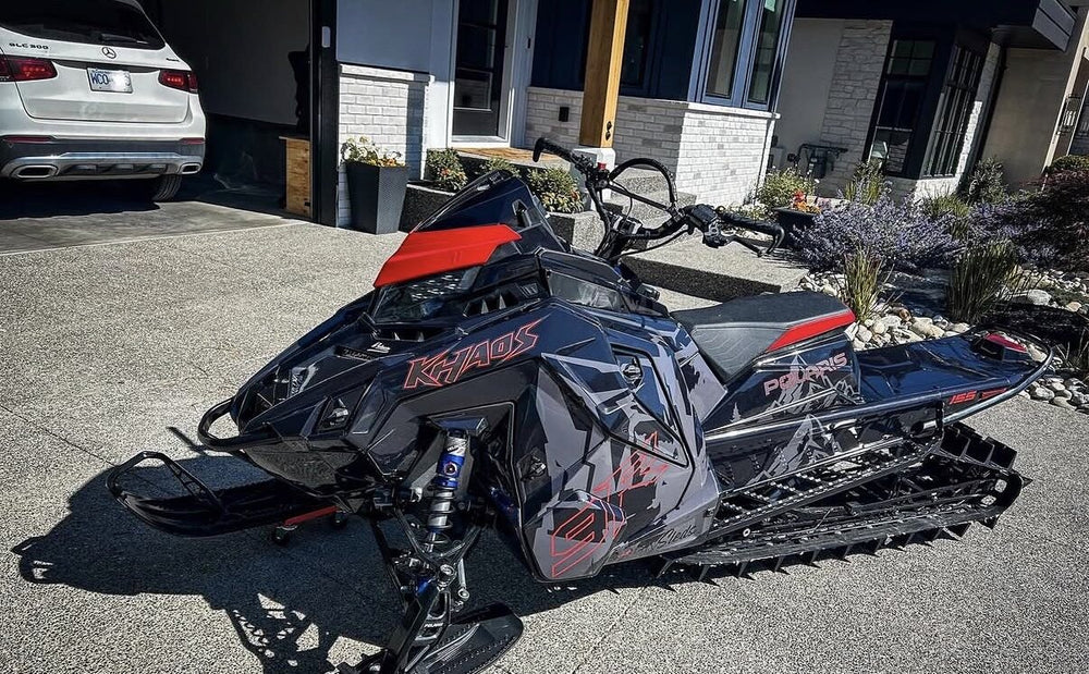Black Polaris snowmobile with custom grey and red graphics