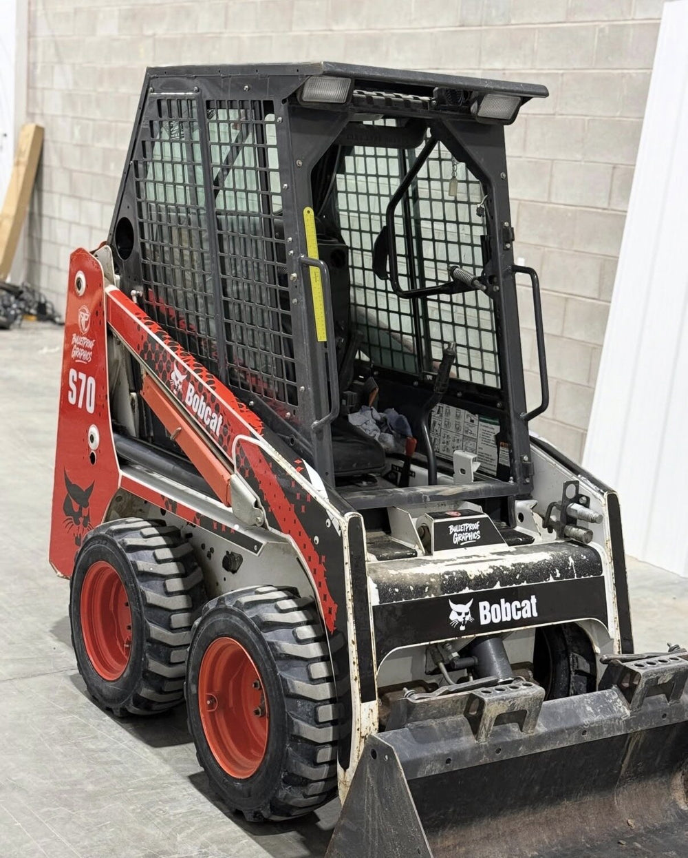 Bobcat skid steer with red and black Bulletproof Graphics decals