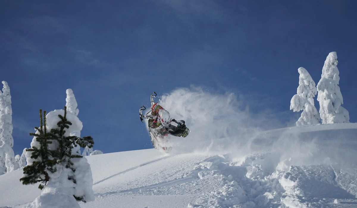 Snowmobile riding through deep mountain powder