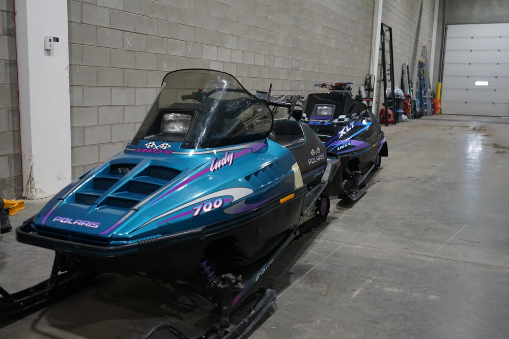 Teal and purple vintage Polaris Indy graphics in the workshop